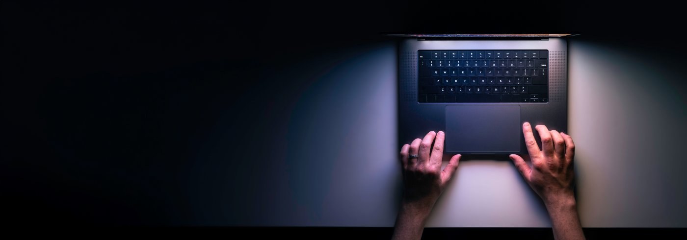 Laptop von oben auf dunklem Schreibtisch bei Nacht