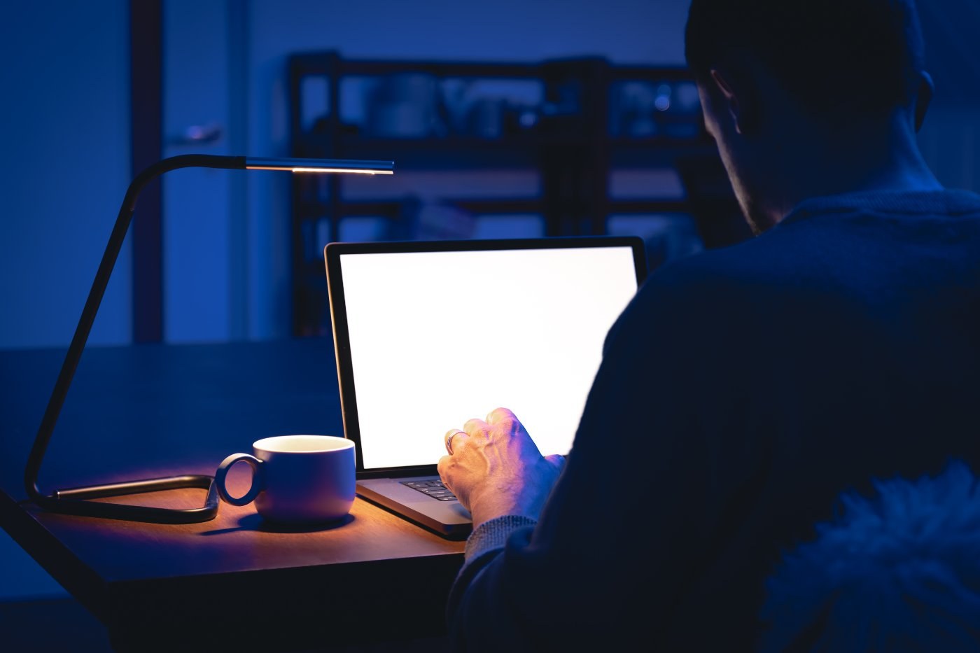 Person arbeitet nachts am Laptop und wertet die Daten einer Landingpage aus
